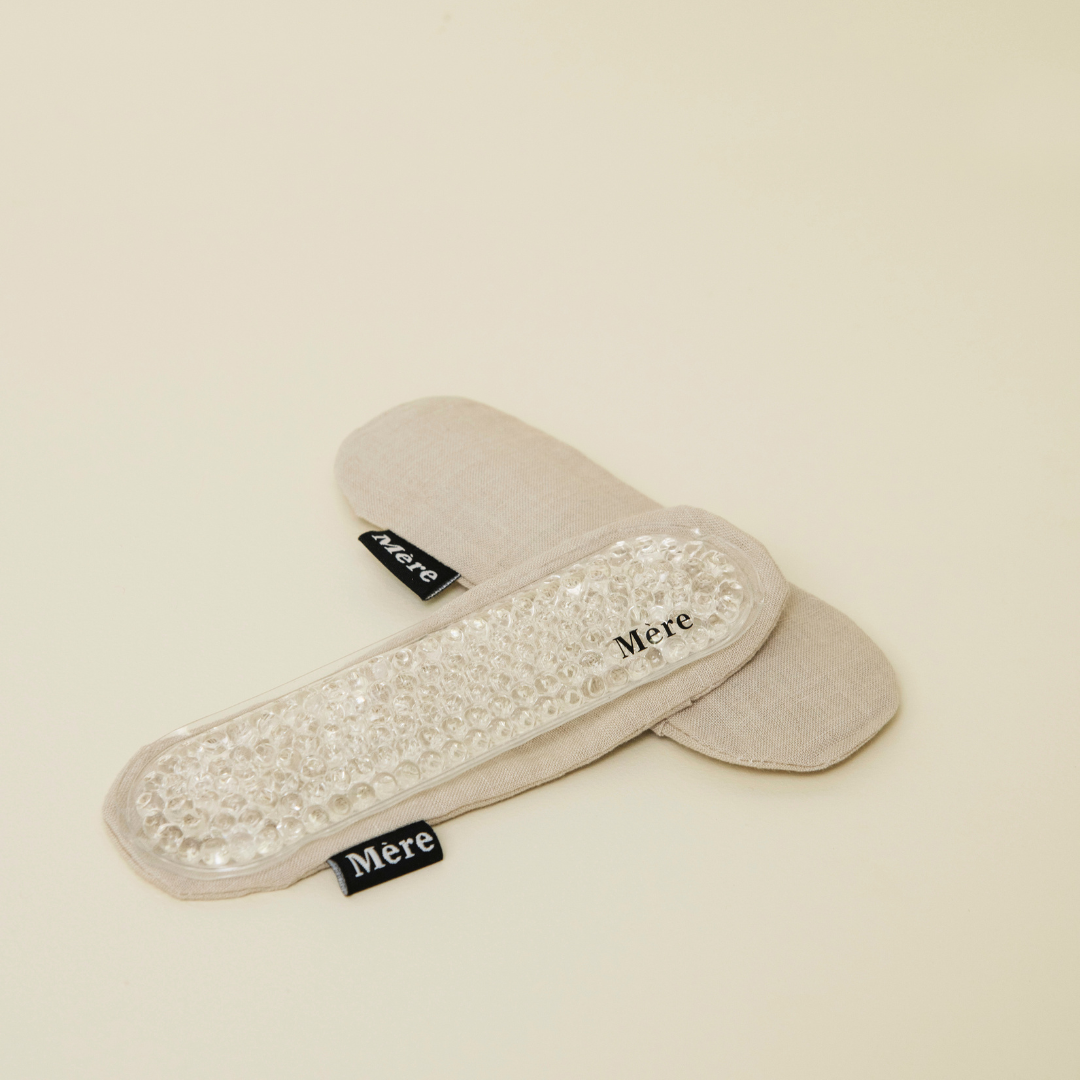 Mere Botancals perineal ice heat pack laying flat on top of neutral linen cover 