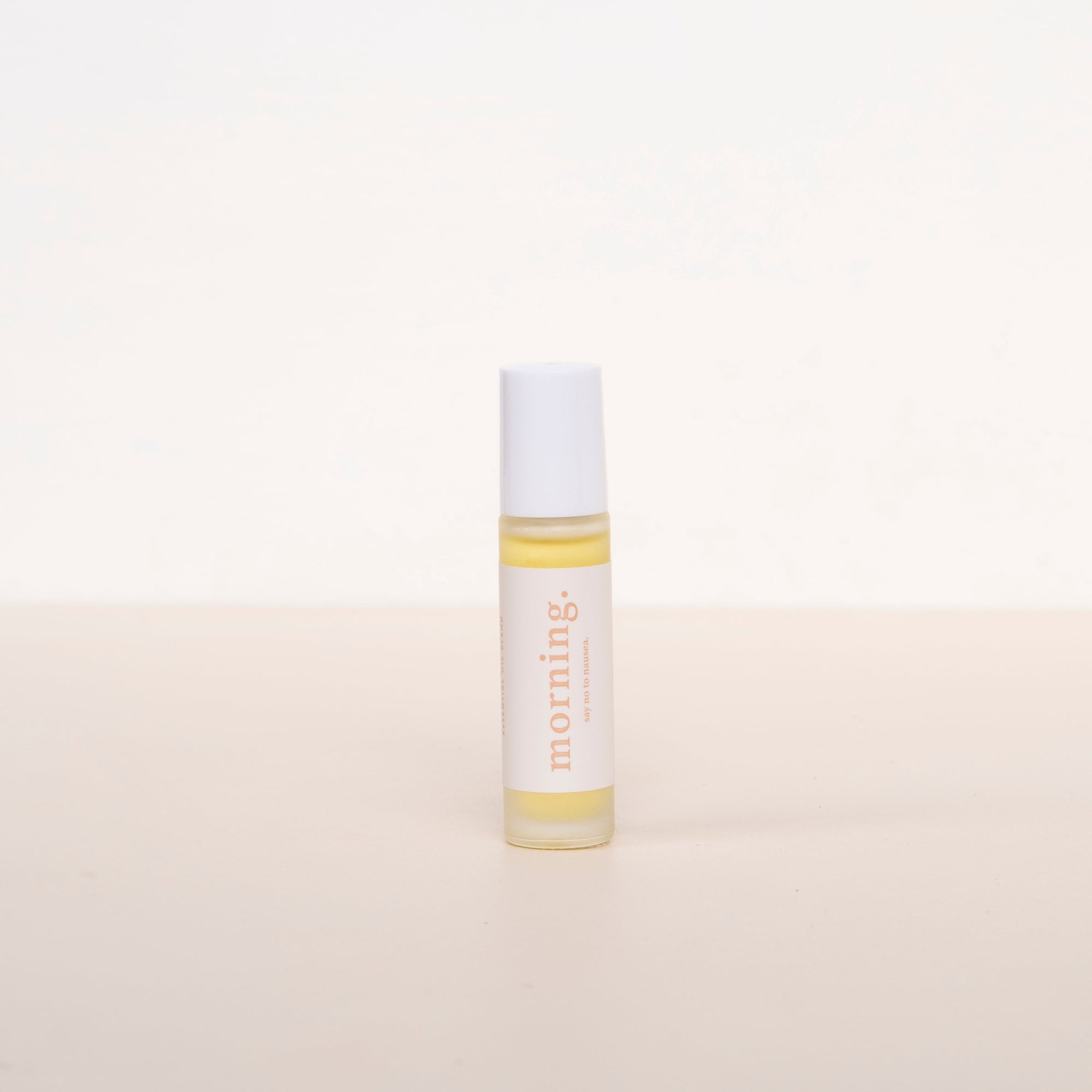 Cle naturals morning essential oil roller blend standing upright against a neutral background, glass oil roller bottle with white label and white lid