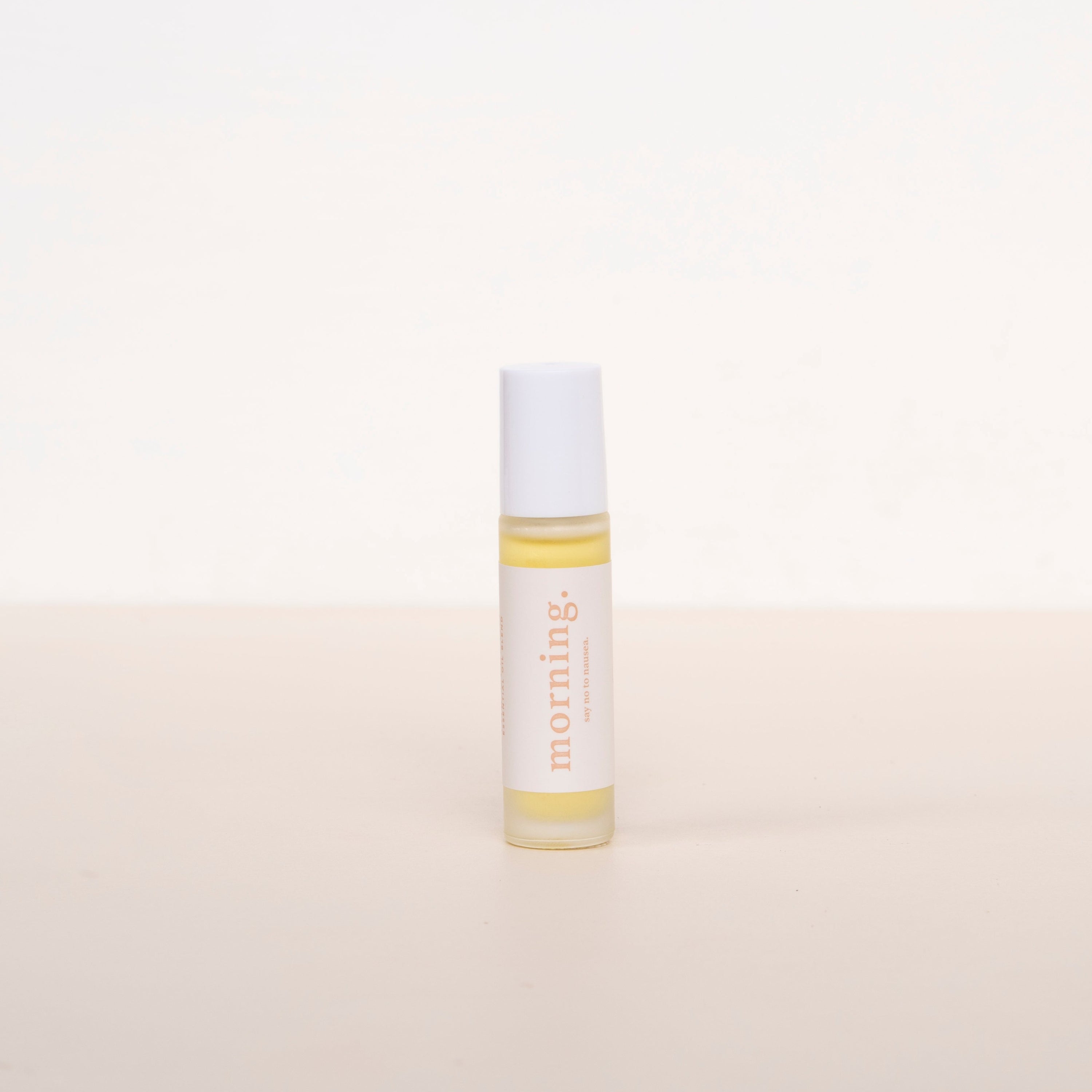 Cle naturals morning essential oil roller blend standing upright against a neutral background, glass oil roller bottle with white label and white lid