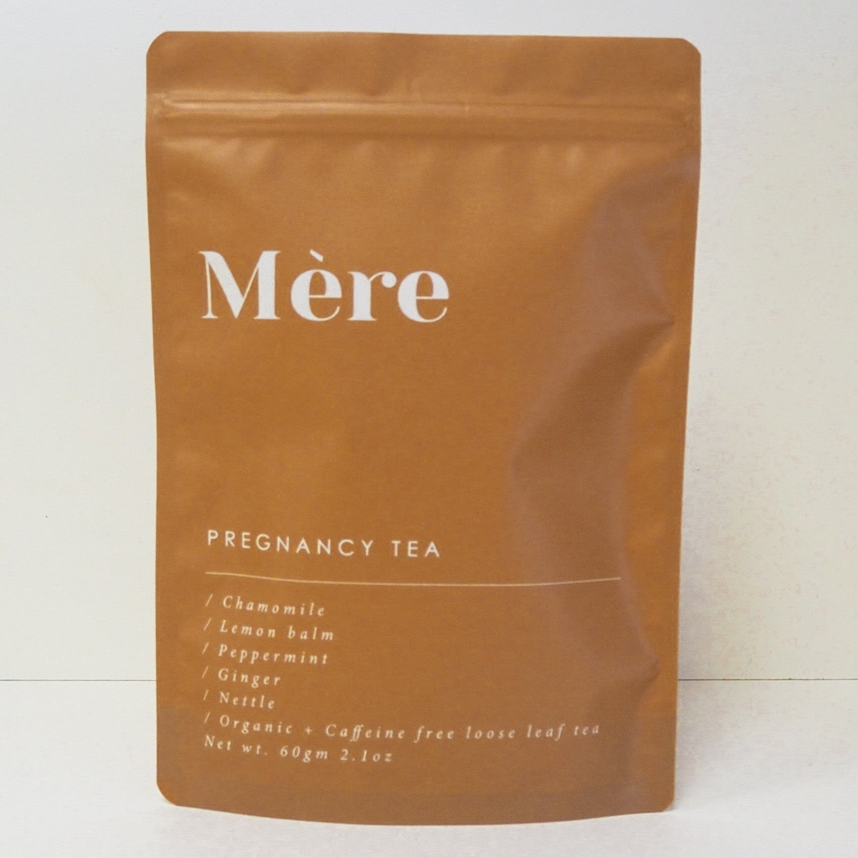 Packet of mere botanicals pregnancy tea standing upright, terracotta cloured bag with zip closing unopened standing in fromt of neutral background